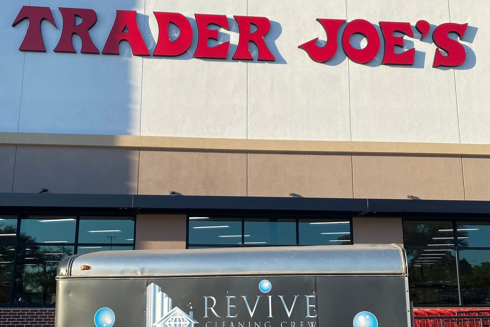 The Revive Cleaning Crew equipment trailer parked outside a Trader Joe's storefront