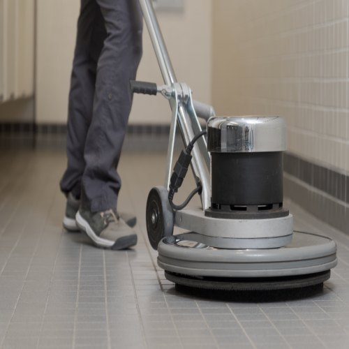 Revive Cleaning Crew technician running a rotary floor machine on tile in San Antonio